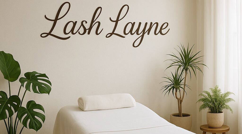 Tranquil treatment room at Lash Layne, Azle, Texas, US with plants and a cozy massage bed.