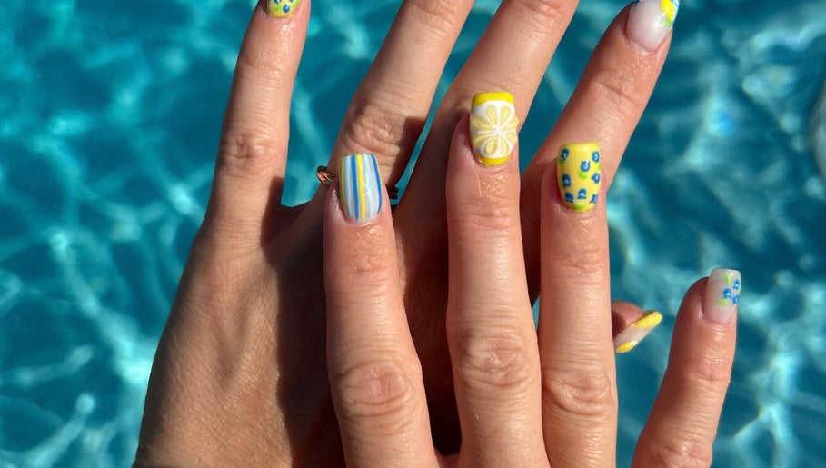 Bright nail art with lemon designs at The Polished Farmgirl, Pembroke, Ontario, CA by a turquoise pool.