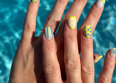 Bright nail art with lemon designs at The Polished Farmgirl, Pembroke, Ontario, CA by a turquoise pool.