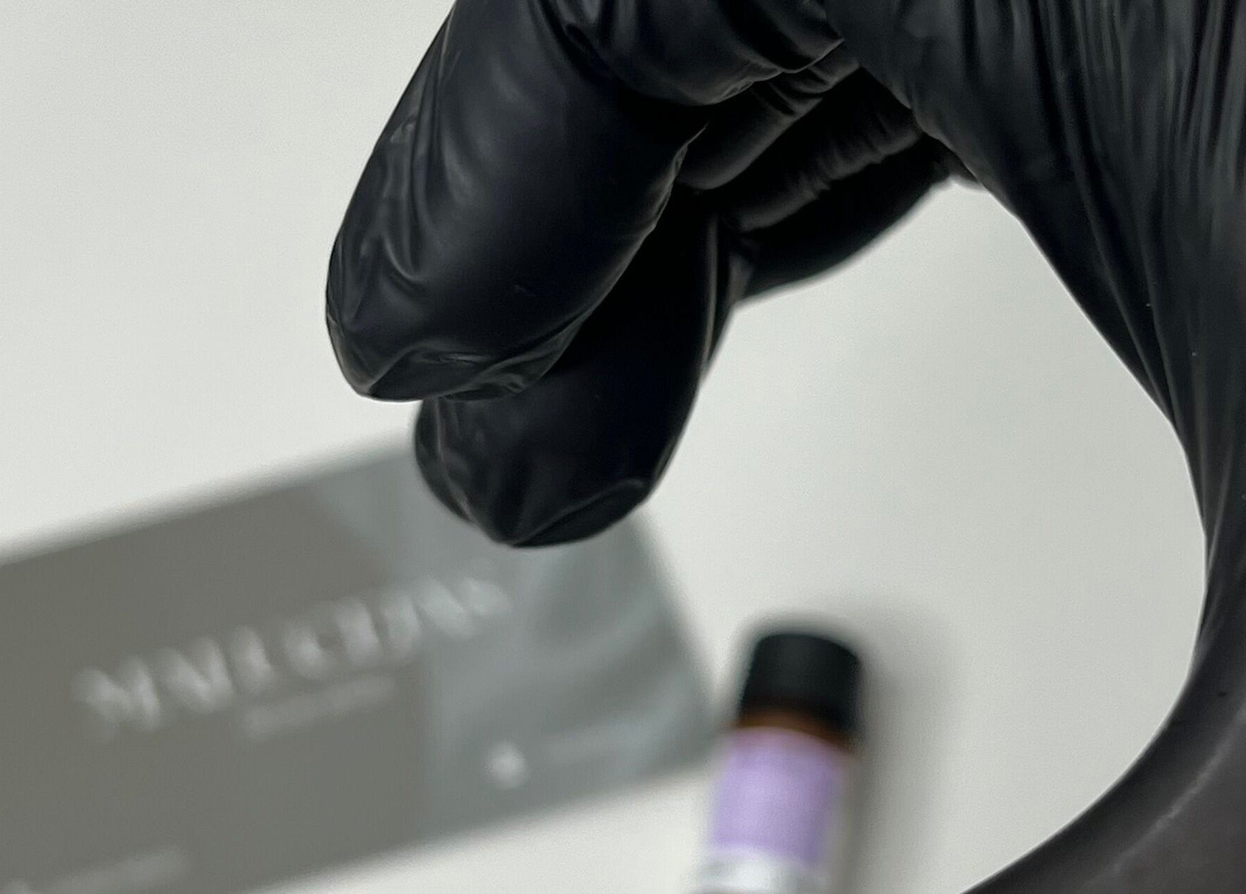 Mano enguantada en negro enfocando tarjeta de Malucejas, Quilicura, Región Metropolitana, CL.