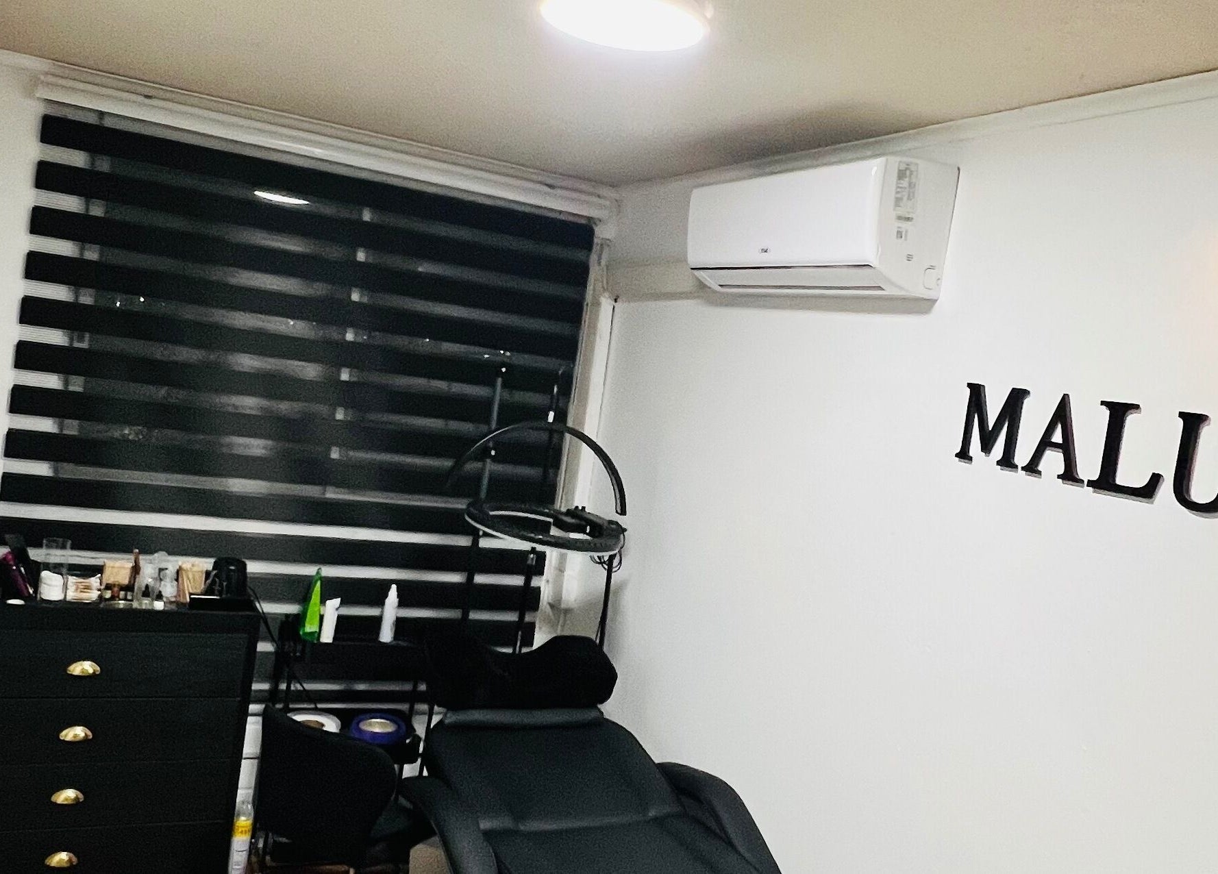 Interior de Malucejas en Quilicura, Región Metropolitana, CL, con silla de tratamiento y estante moderno.