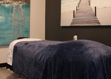 Cozy massage room at Advanced Massage Therapy in Winnipeg, Manitoba, CA, featuring calming artwork.