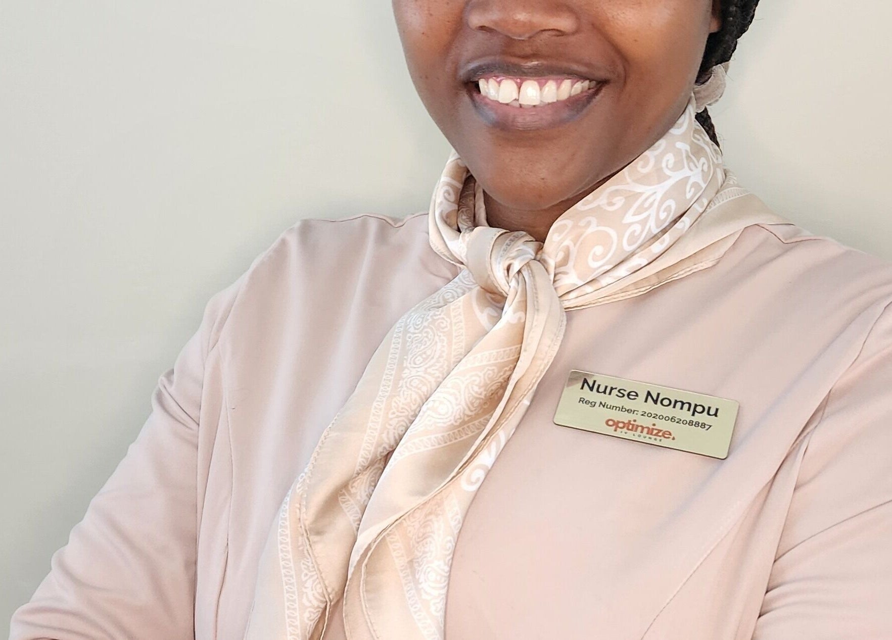 Smiling staff member at Optimize IV Lounge, Randburg, Gauteng, ZA, wearing a name badge.