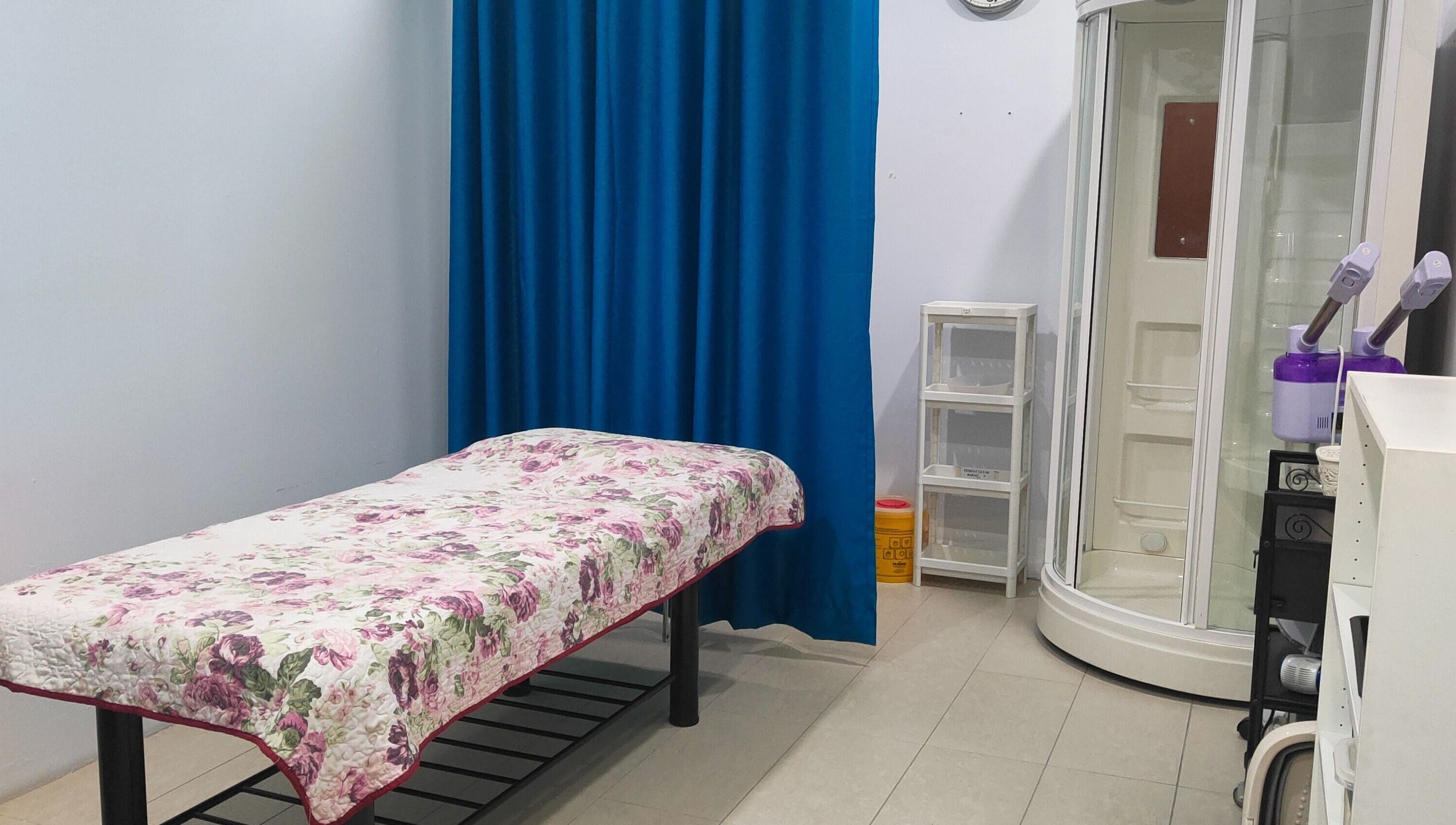 Massage room at Rumah Sihat Senawang, featuring a floral bedspread, located in Seremban, Negeri Sembilan, MY.