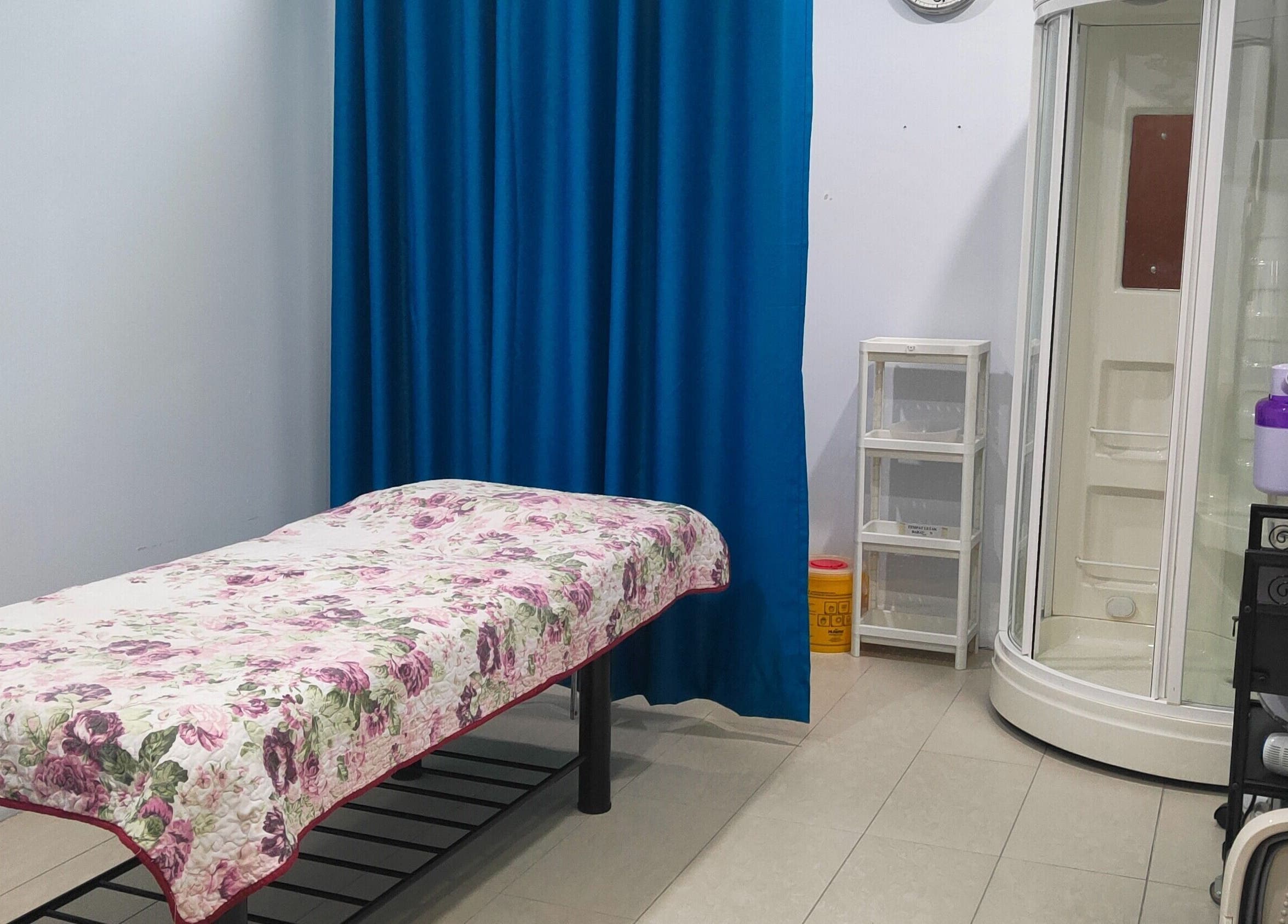 Massage room at Rumah Sihat Senawang, featuring a floral bedspread, located in Seremban, Negeri Sembilan, MY.