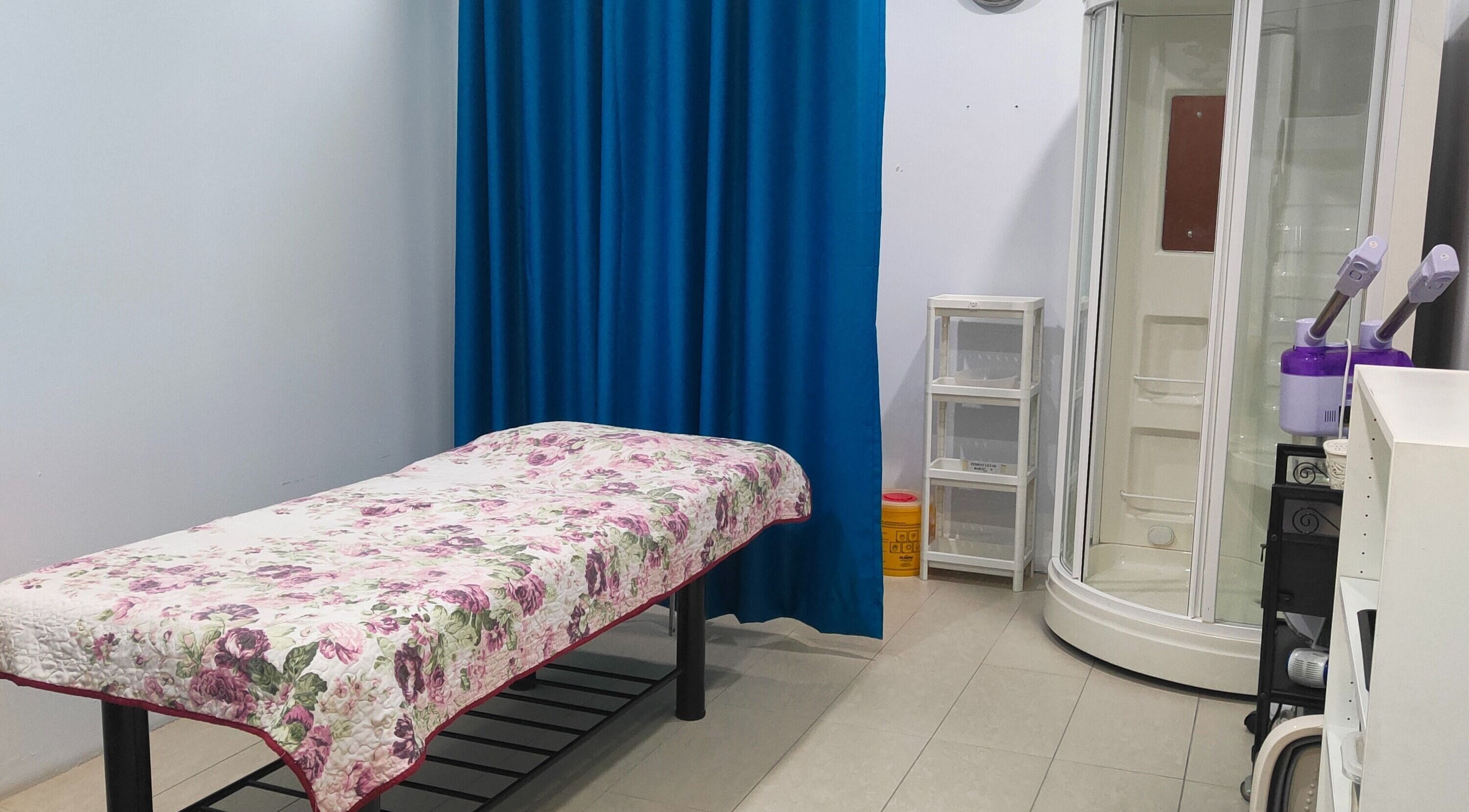 Massage room at Rumah Sihat Senawang, featuring a floral bedspread, located in Seremban, Negeri Sembilan, MY.