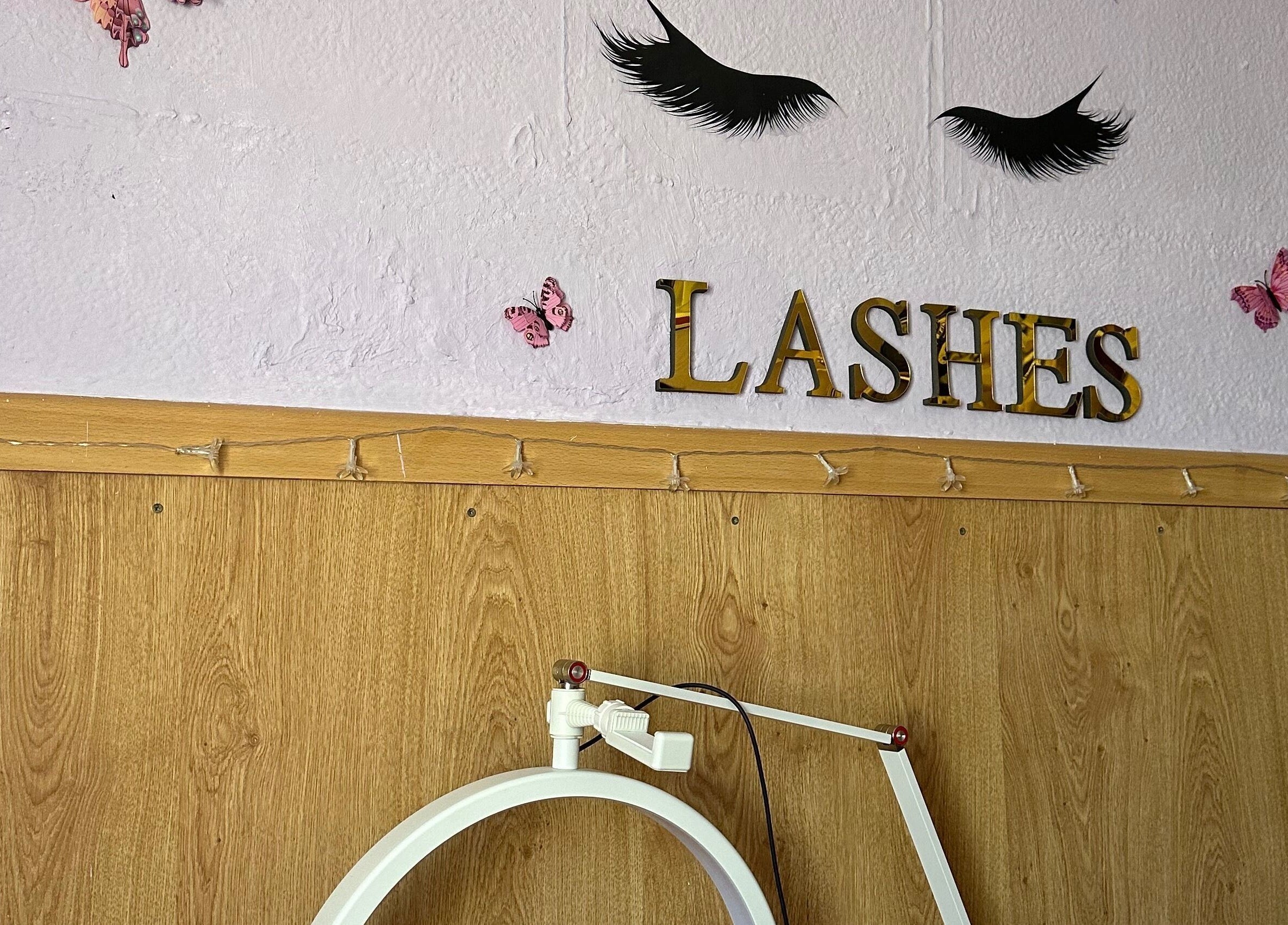 Interior decorado en Studio Obsessive Lashes, La Línea De La Concepción, con adornos de pestañas y mariposas.