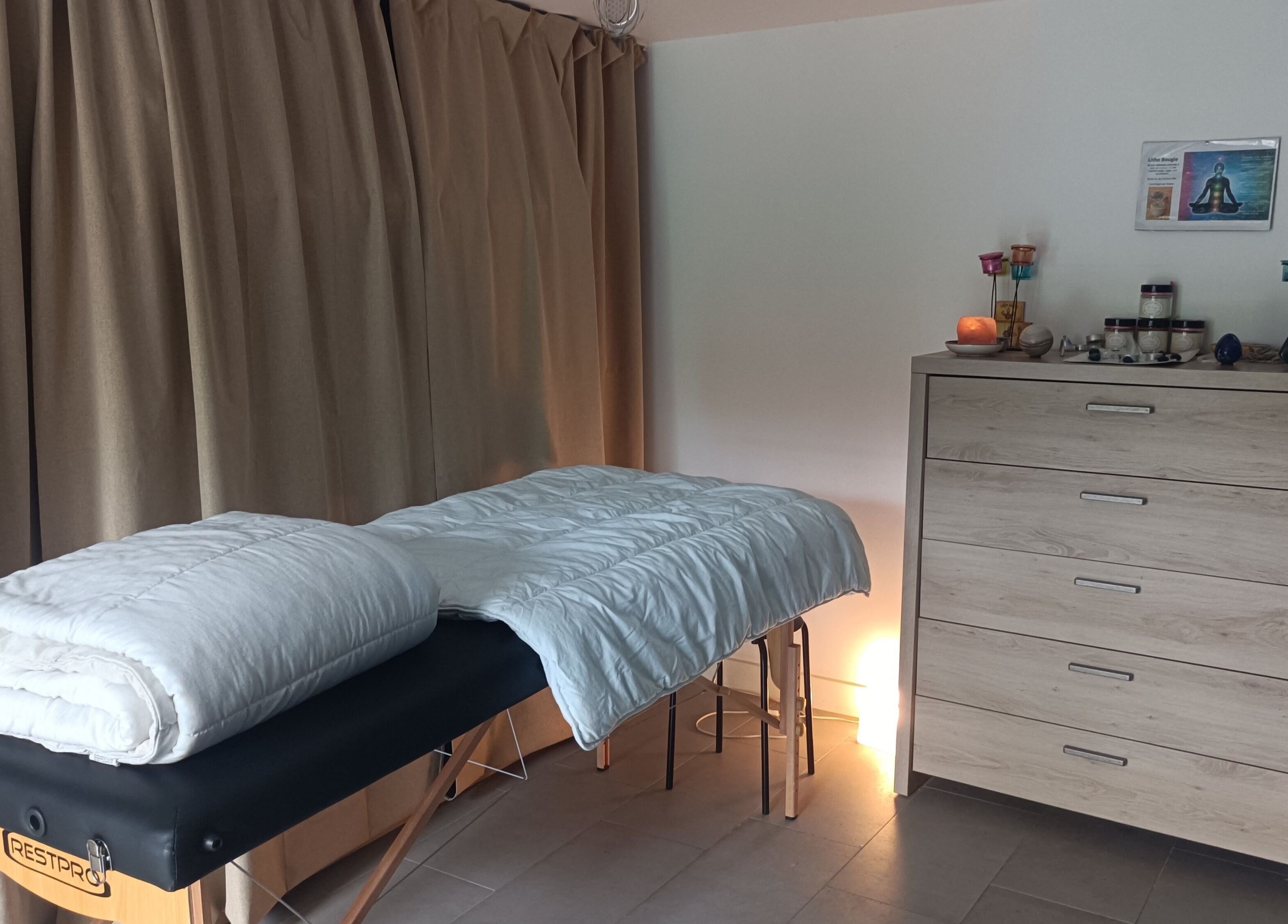 Salle de soins Un Souffle Nouveau à Schaerbeek, Bruxelles, équipée d'une table de massage et de bougies apaisantes.