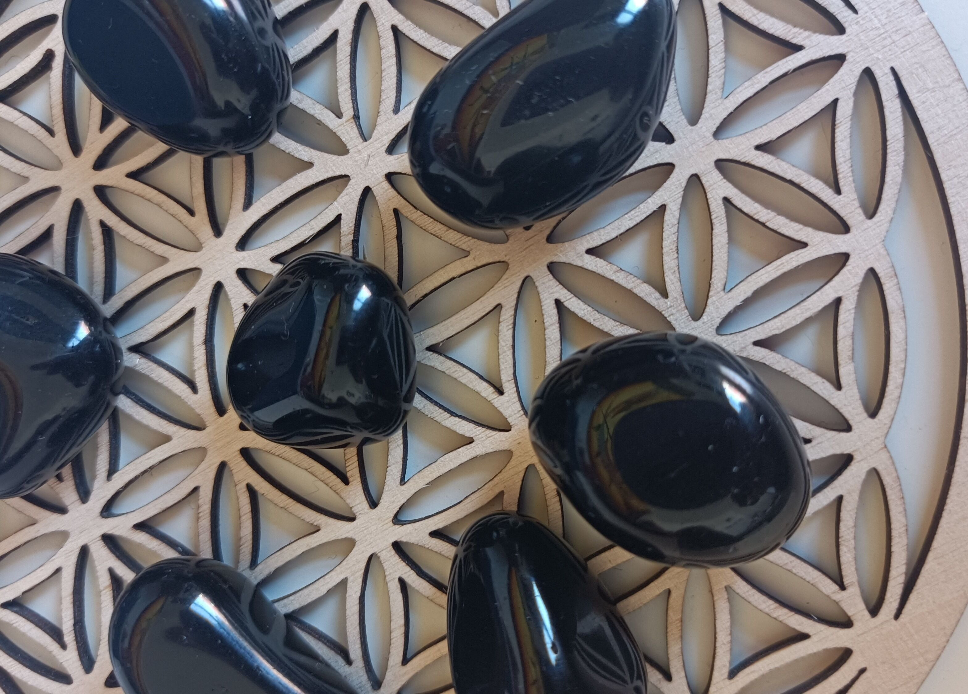 Pierres obsidiennes sur motif géométrique chez Un Souffle Nouveau / Soins énergétiques, Schaerbeek, Bruxelles, BE.