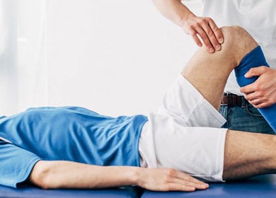 Therapist performs sports therapy on a patient at RMT Sports Therapy, Cross Hands, Wales, GB.
