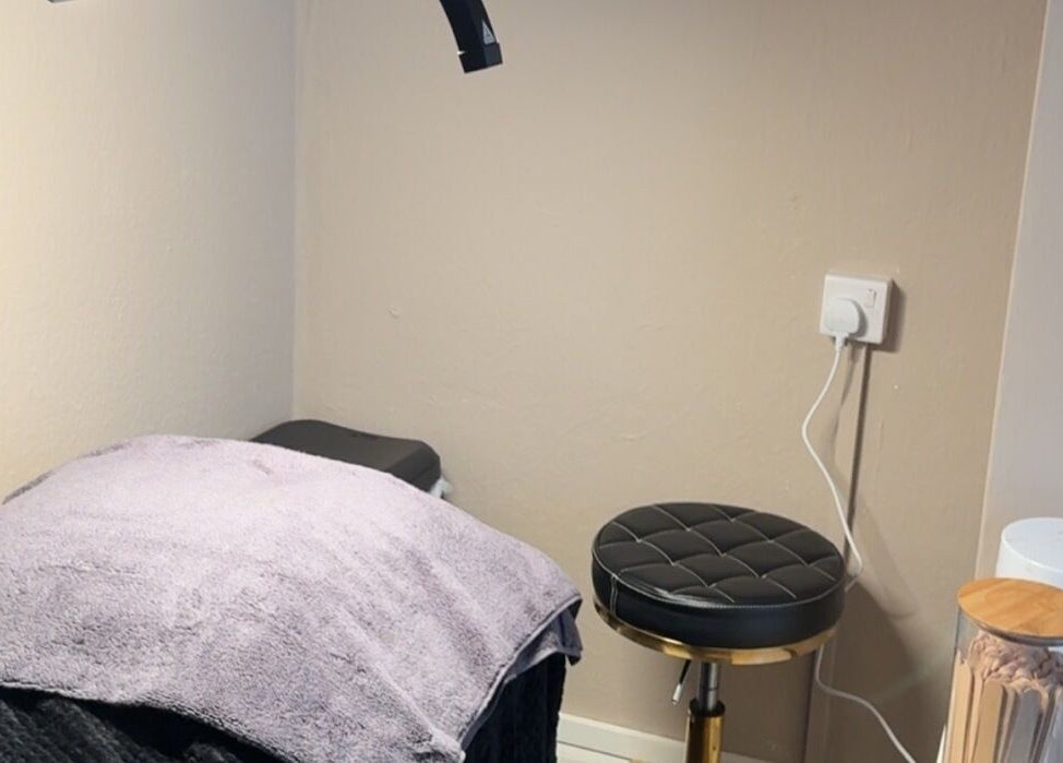 BeautyByElls private treatment nook in Ilkeston, England with a plush bed and stool.
