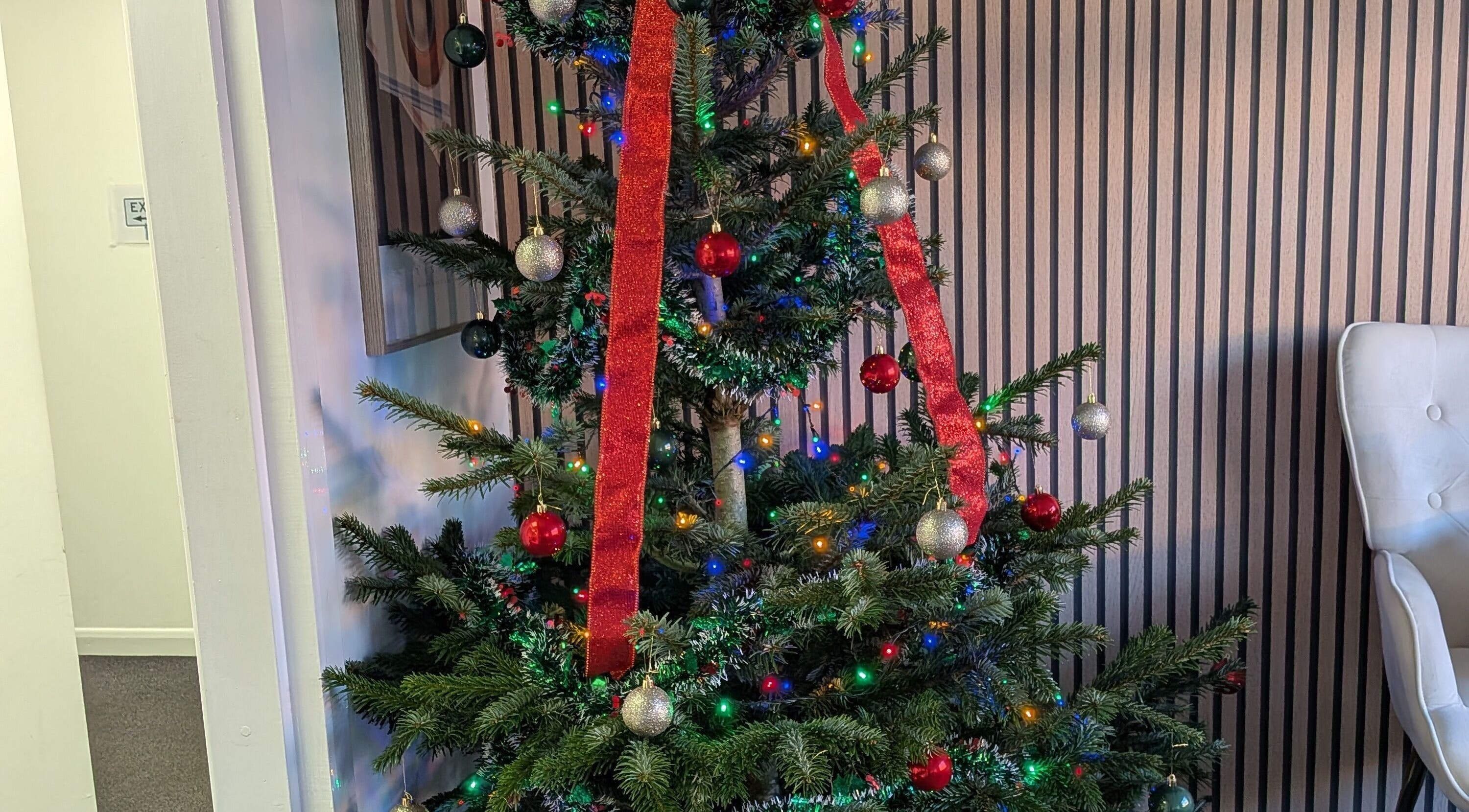 Christmas tree adorned in Beauty Within, Castleford, England, GB with colorful lights and ornaments.