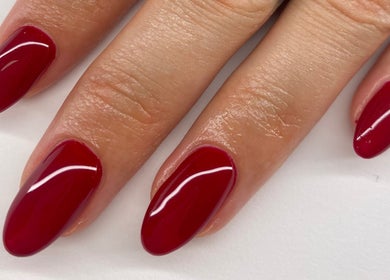 Mains avec vernis rouge éclatant chez SC Nails, Izon, Nouvelle-aquitaine, FR.