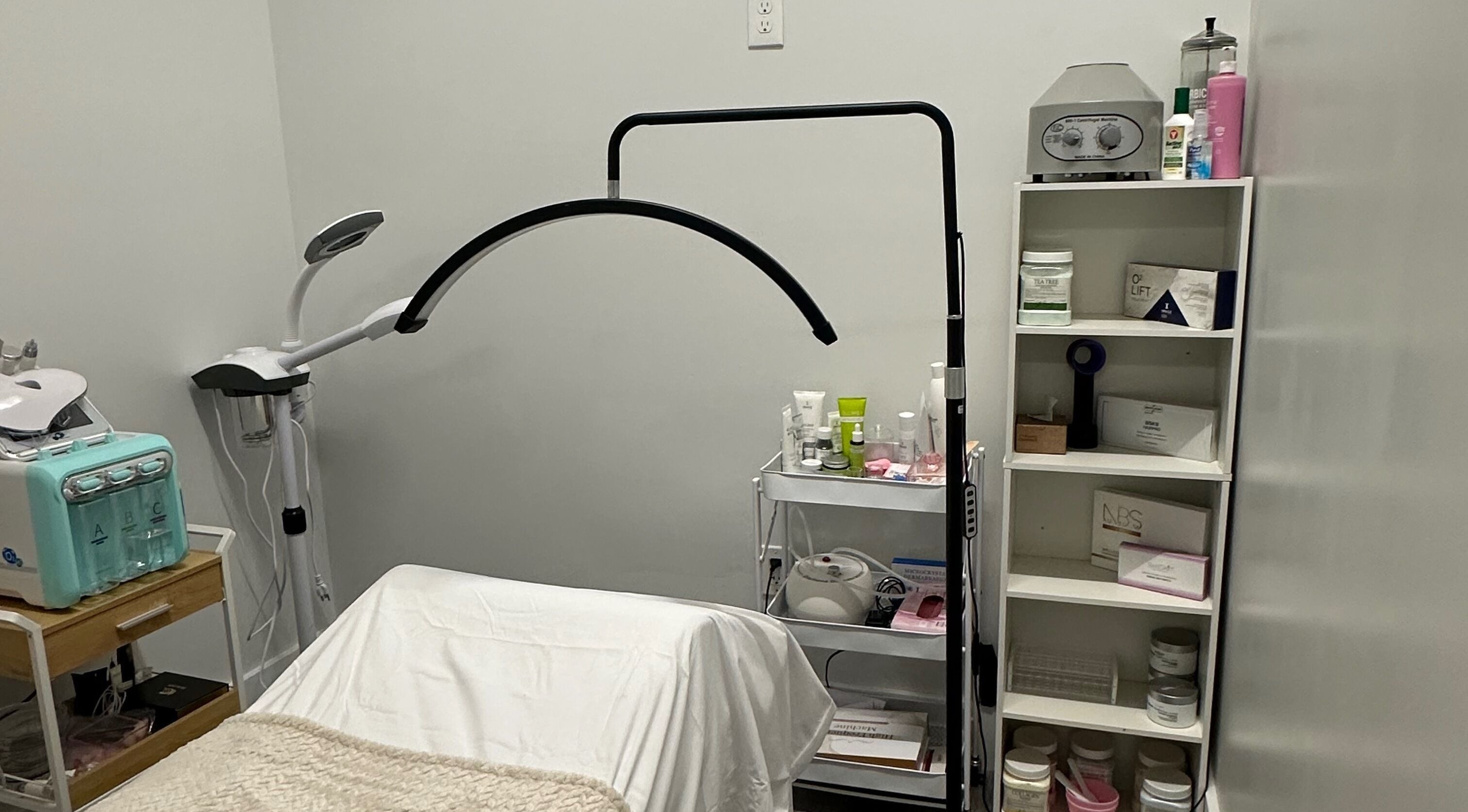 Sala de tratamientos en SC Beauty Spa, Orlando, Florida, US con equipo moderno y estantería organizada.