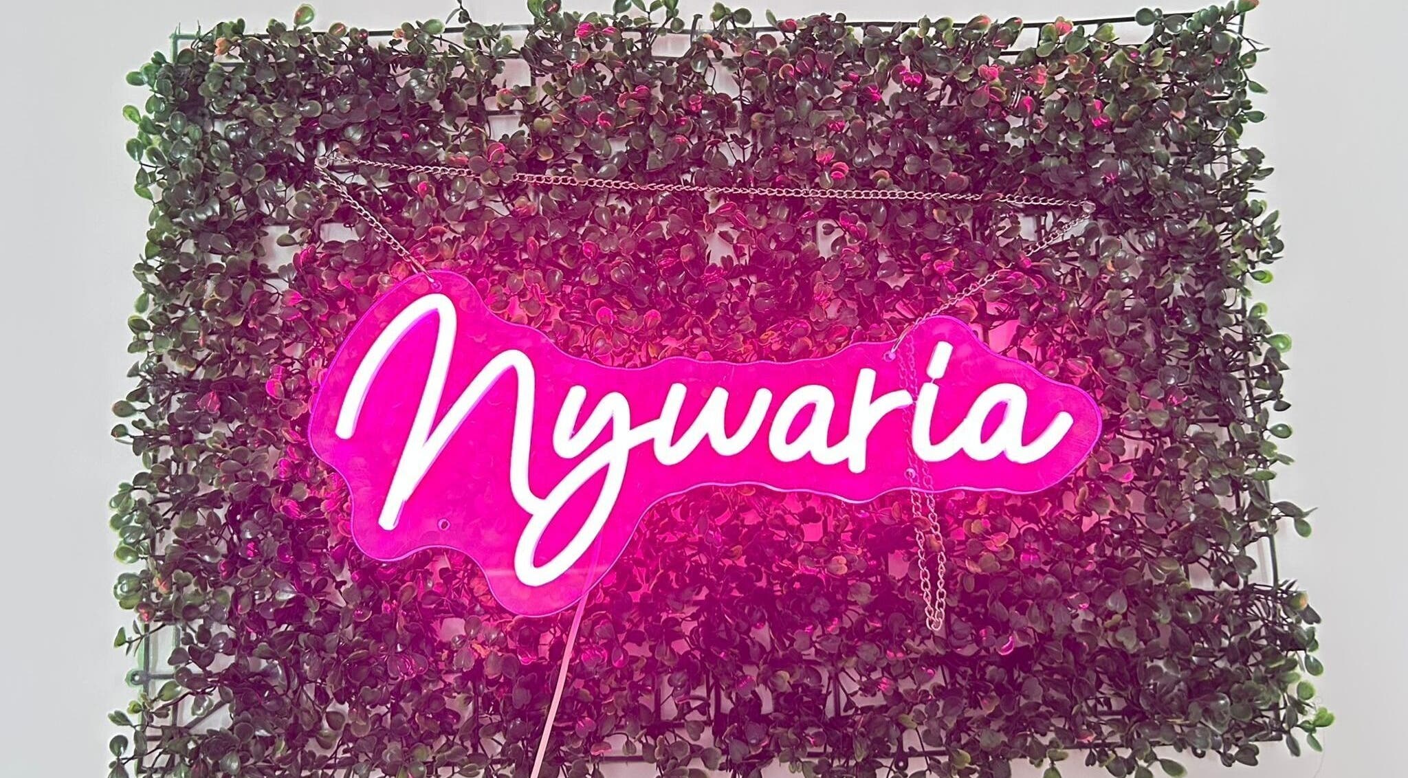 Enseigne lumineuse rose de Nywaria sur fond de feuillage à Gatineau, Québec, CA.