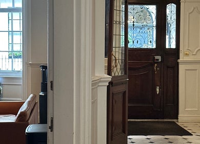 Elegant entrance area at Christina Bethany, London, England, GB showcasing classic wooden doors and bright interior.