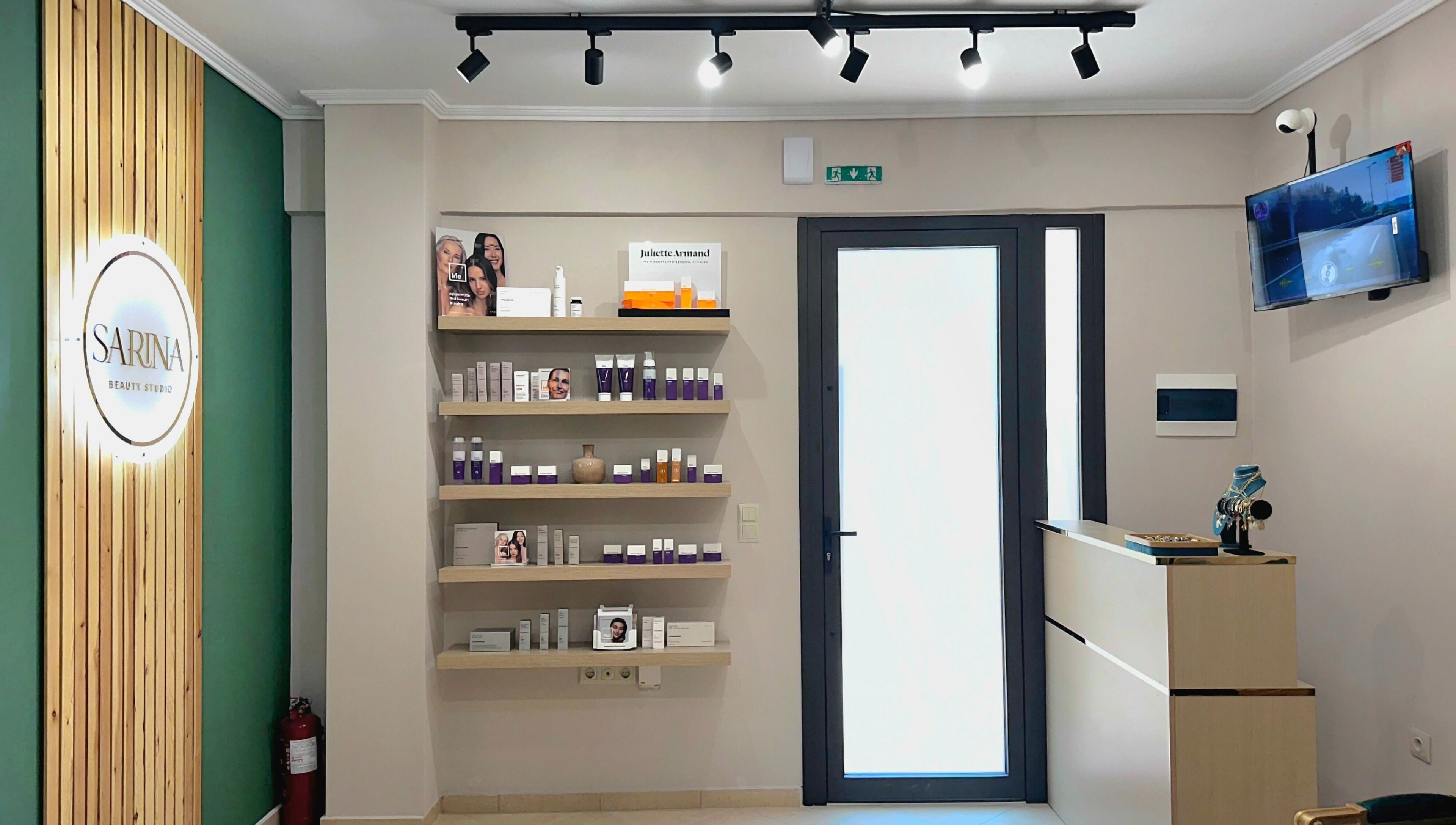Υποδοχή Sarina Beauty Studio στην Ευκαρπία GR με προϊόντα ομορφιάς σε ξύλινα ράφια.