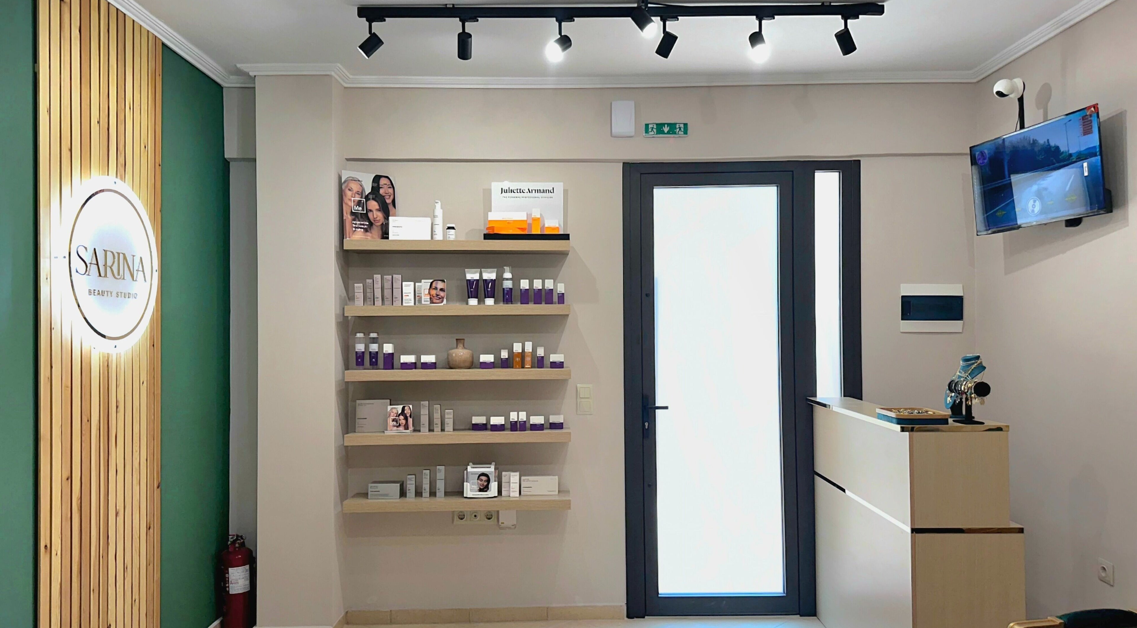 Υποδοχή Sarina Beauty Studio στην Ευκαρπία GR με προϊόντα ομορφιάς σε ξύλινα ράφια.