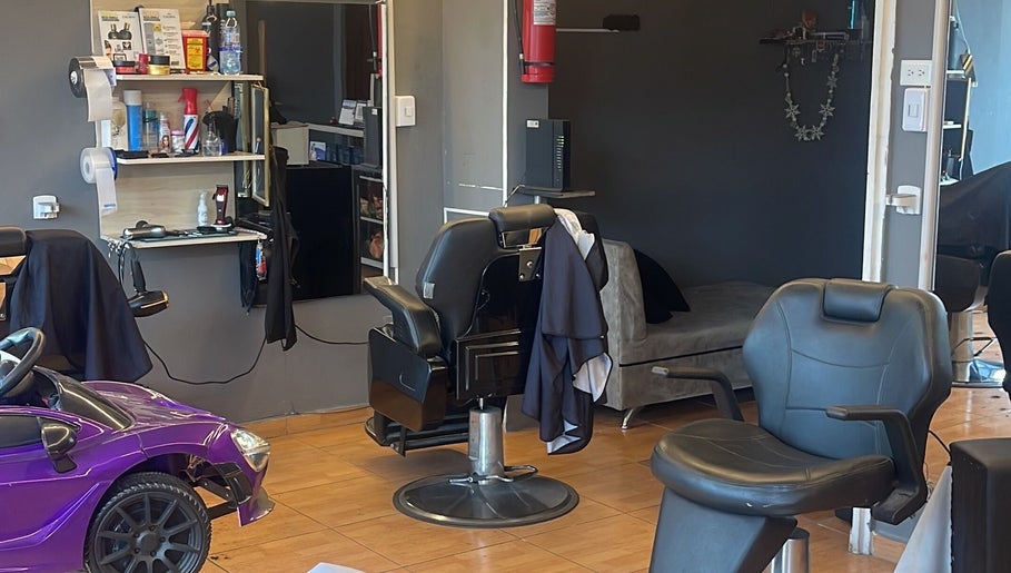 Interior moderno de Visionary Barber Shop en Santo Domingo, EC con sillas de peluquería elegantes.