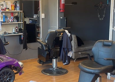 Interior moderno de Visionary Barber Shop en Santo Domingo, EC con sillas de peluquería elegantes.