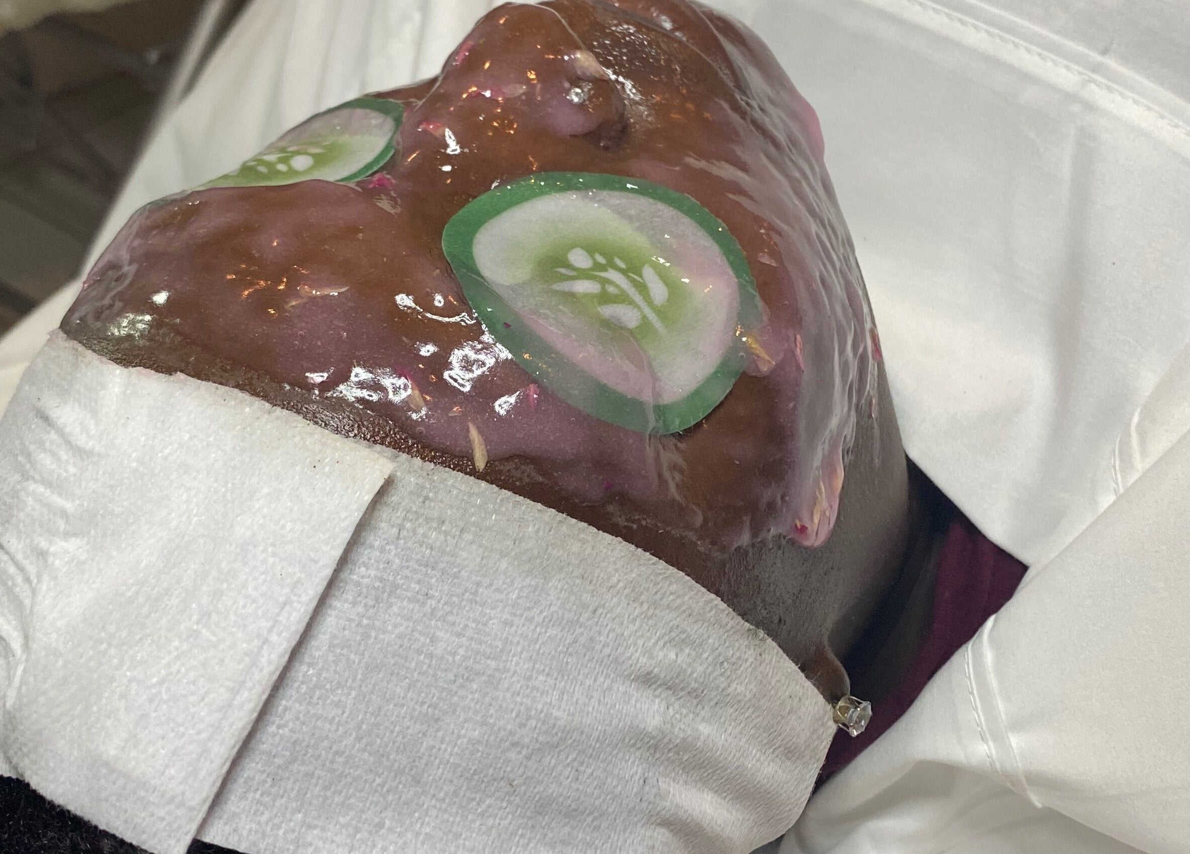 Facial treatment at Pampered Skin Oasis in Nassau, New Providence, BS with cucumber mask for skin rejuvenation.