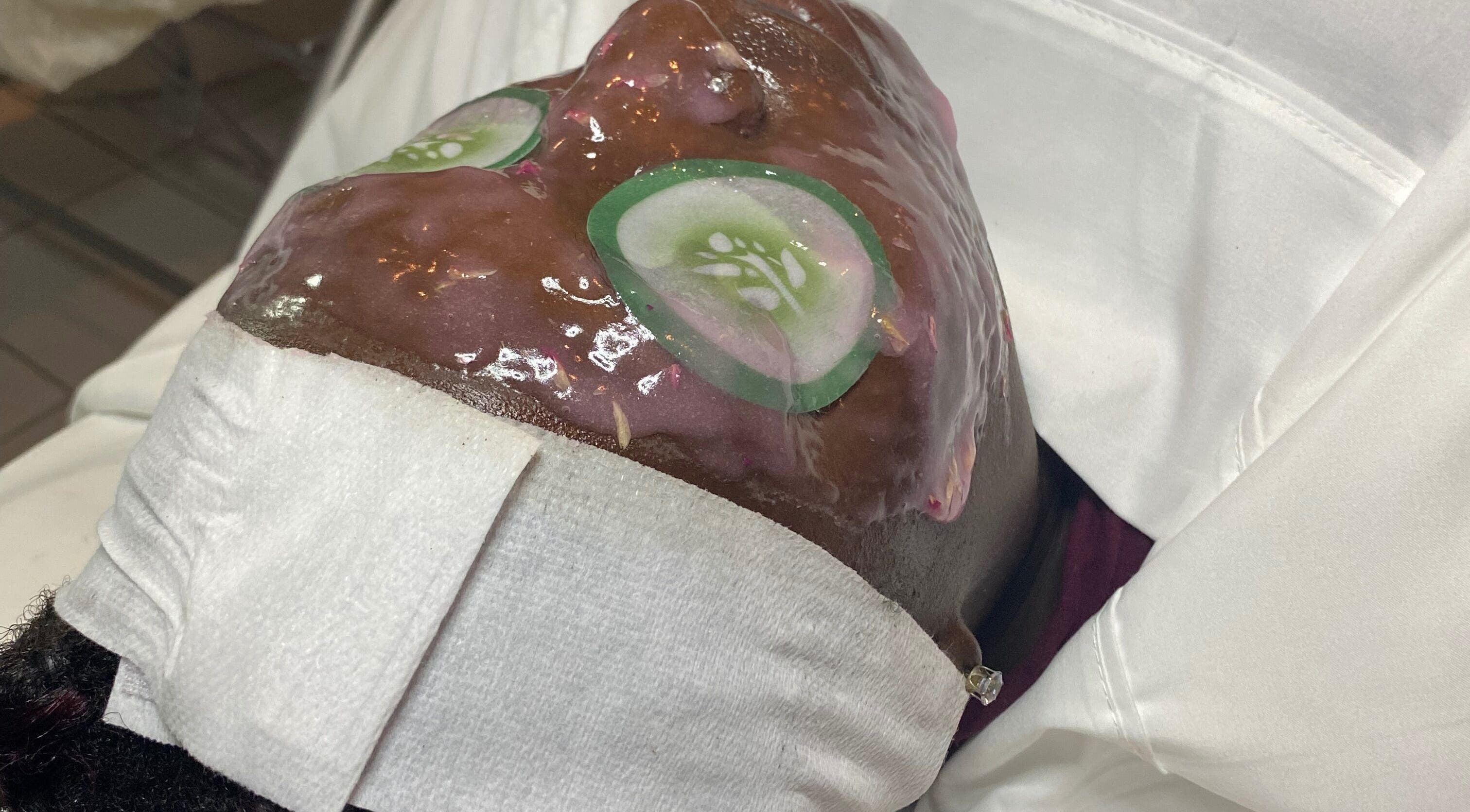 Facial treatment at Pampered Skin Oasis in Nassau, New Providence, BS with cucumber mask for skin rejuvenation.