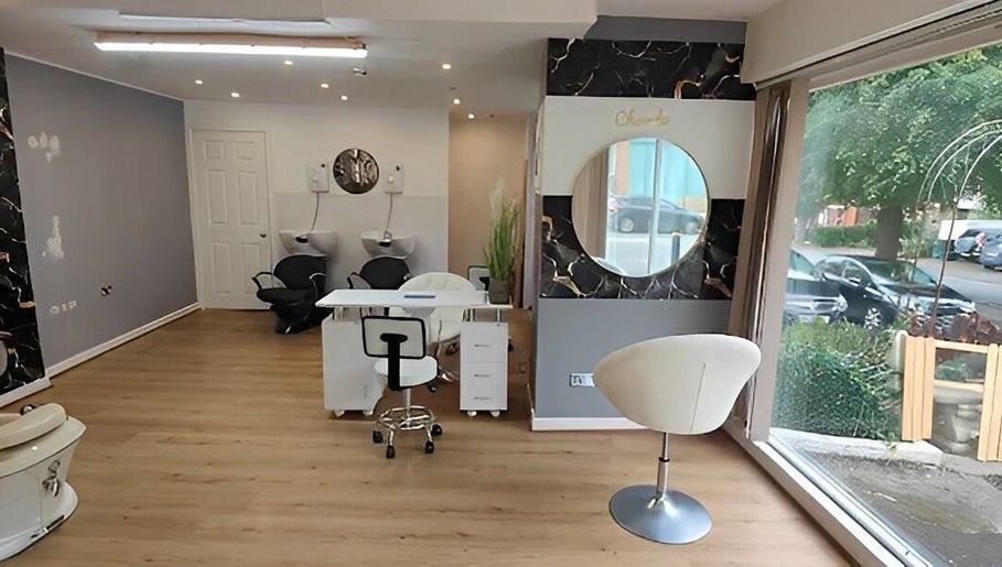 Chic interior of Chandu Hair & Beauty, Colwyn Bay, Wales, GB, featuring styling chairs and large mirrors.