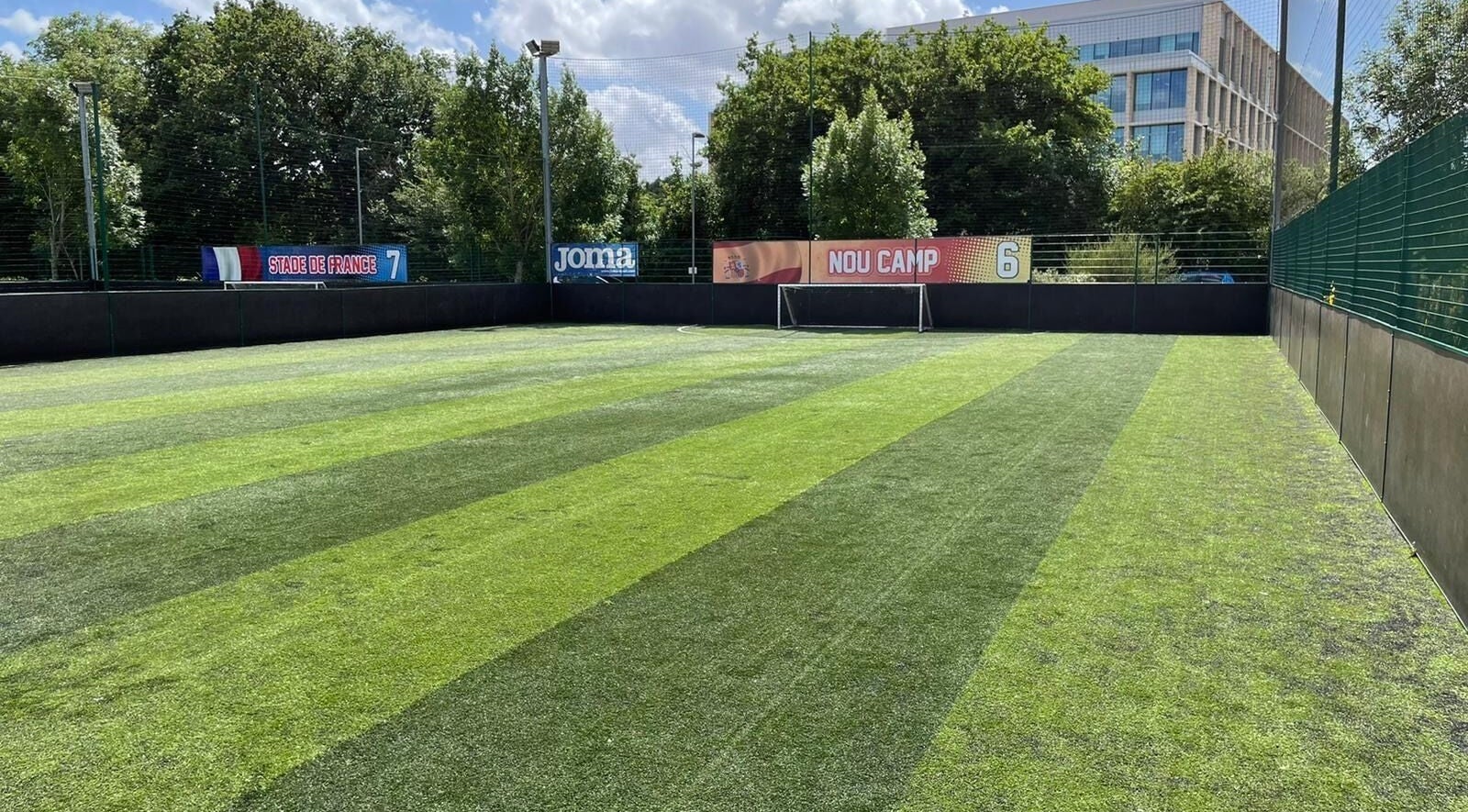 Pristine football field at SW Football Academy, Tolworth, England, GB under a bright sky.