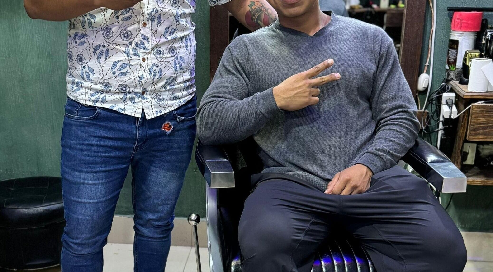 Cliente sonriente en Óptima Figaros, Santa Catarina Barahona, Sacatepéquez, GT, mostrando signo de paz.