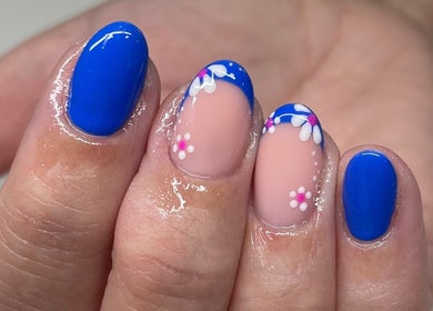 Bright blue nails with floral designs by Perfections Nails and Beauty, Winsford, England, GB.
