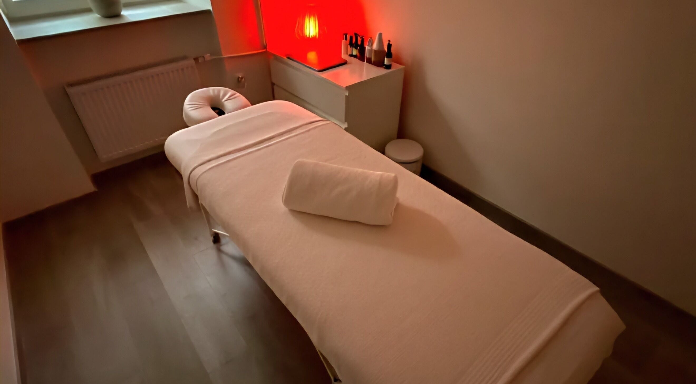 Relaxing massage room at The Room, Melbourne, Victoria, AU with ambient lighting and cozy massage bed.