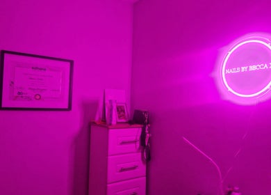 Nailssbybeccax venue in County Mayo, IE with vibrant pink neon lighting decor accentuating the salon ambiance.
