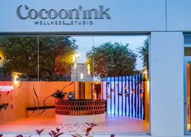 Fachada iluminada de Cocoon’ink Wellness Studio en Mataró, Catalunya, ES, destacando su entrada acogedora.