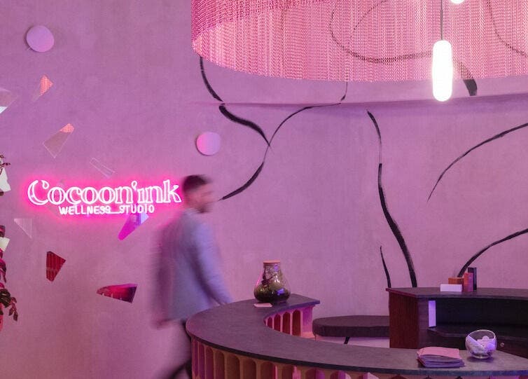 Recepción moderna en Cocoon’ink Wellness Studio, Mataró, Catalunya, ES, con iluminación neón y decoración elegante.