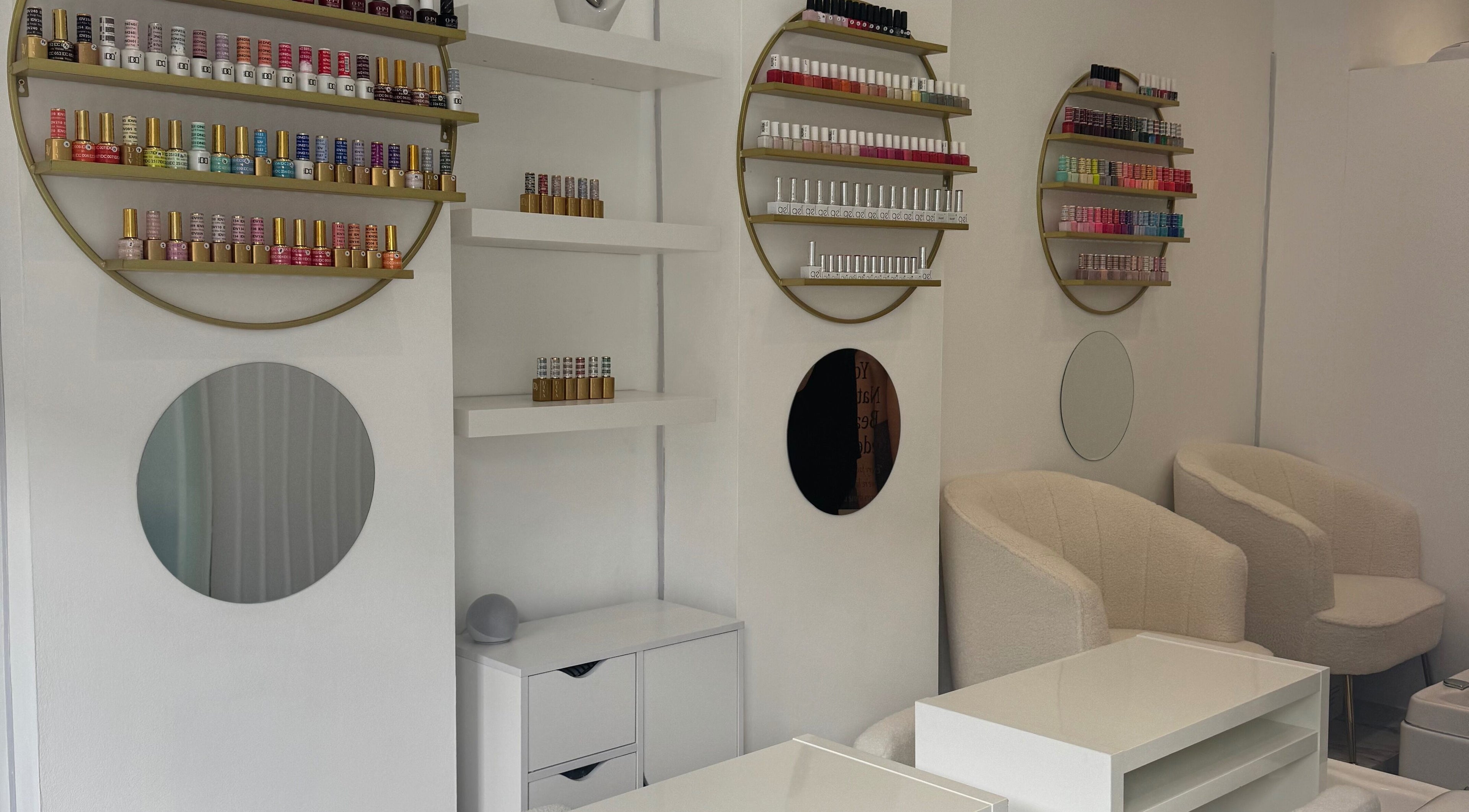 Elegant nail salon interior at Shiny Nails, London, England, GB showcasing cozy chairs and colorful polish displays.