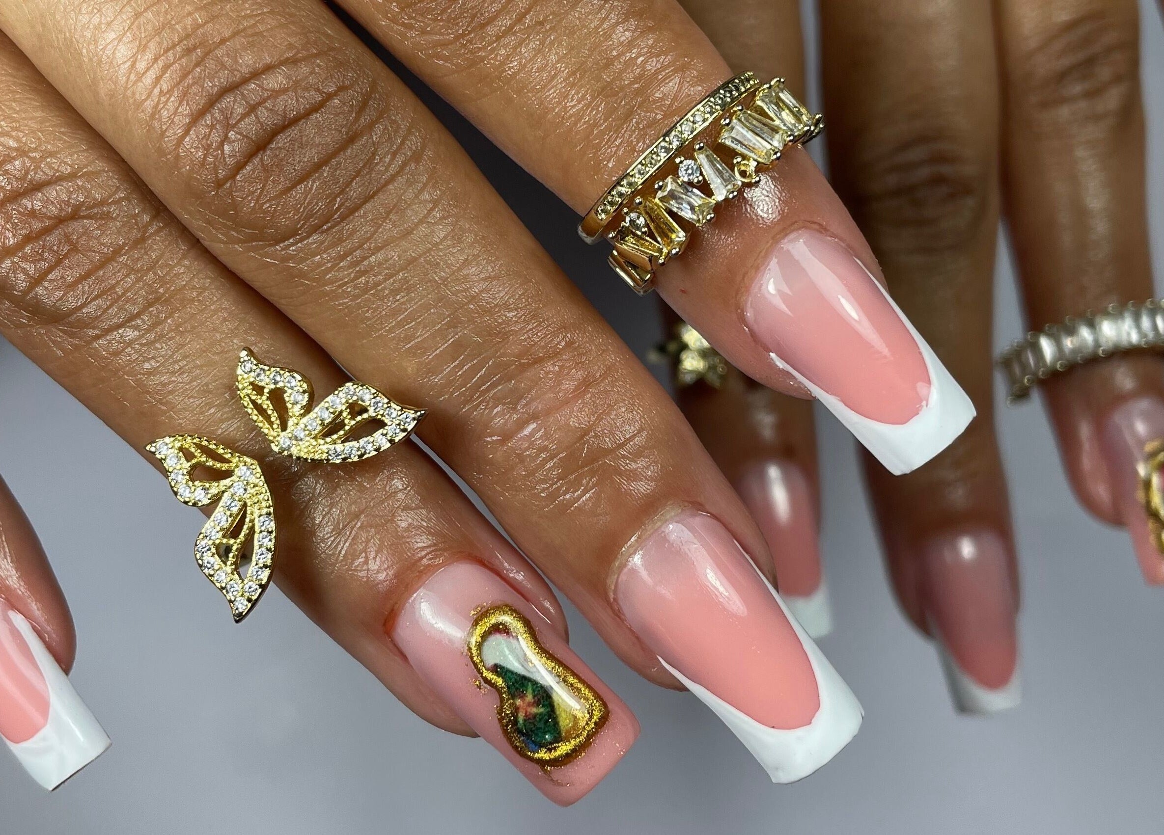 Manucure française élégante chez RK_Nails, Roubaix, Hauts-de-France, FR. Ongles ornés de bagues en or.