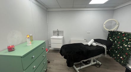 Relaxing treatment room at Get Em Treatments in Aberdeen, Scotland, GB with a floral wall and massage bed.