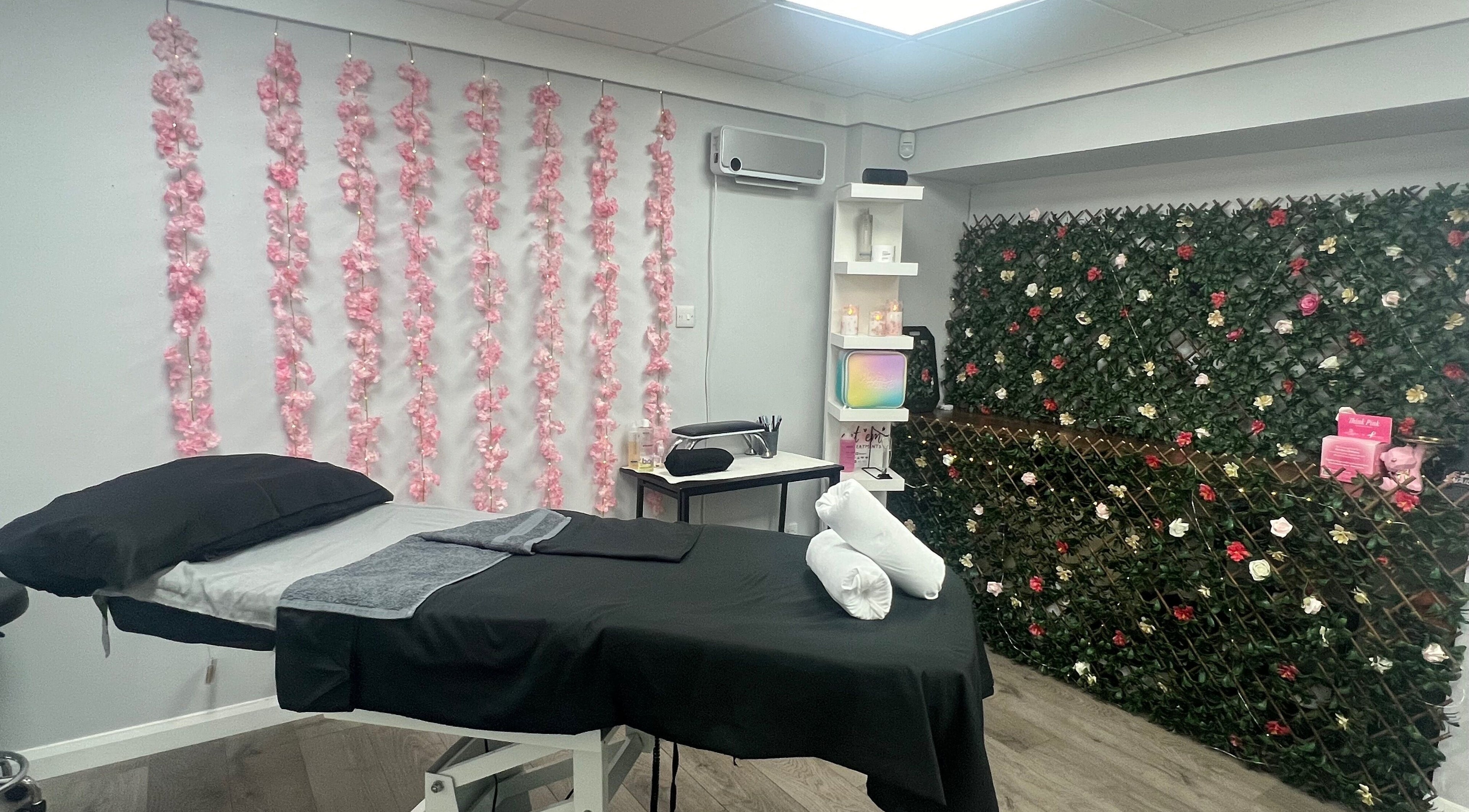 Tranquil treatment room at Get Em Treatments, Aberdeen, Scotland, GB with floral decor and massage table.