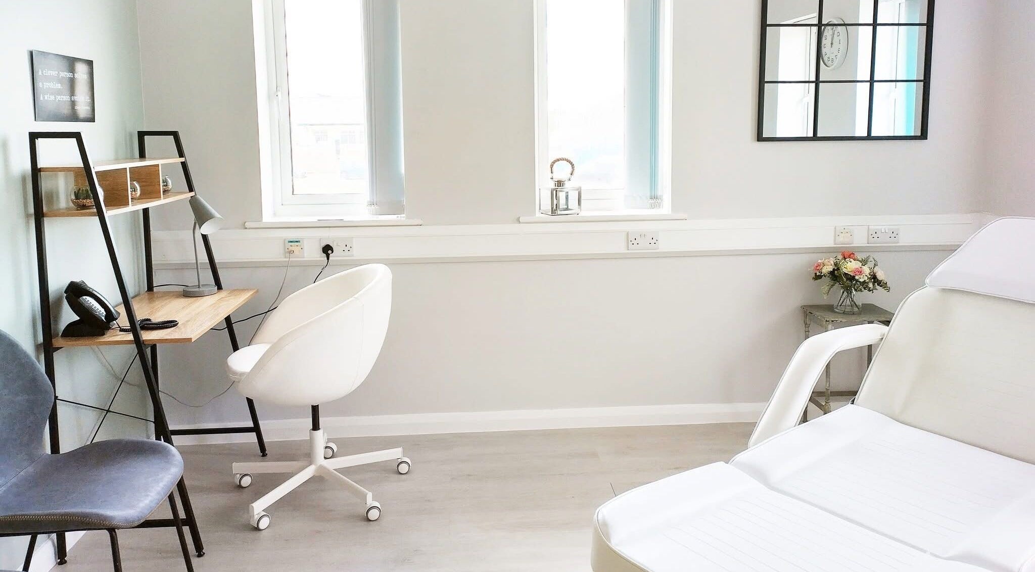 Bright treatment room at Weymouth Aesthetics Clinic, Weymouth, England, GB with stylish decor and white chairs.