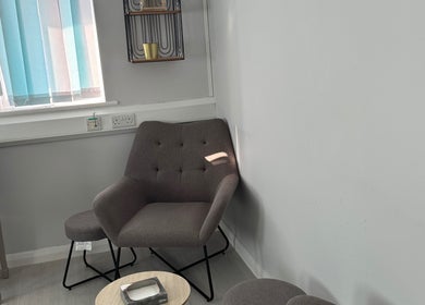 Relaxing seating area at Weymouth Aesthetics Clinic, Weymouth, England, GB, with modern light gray decor.