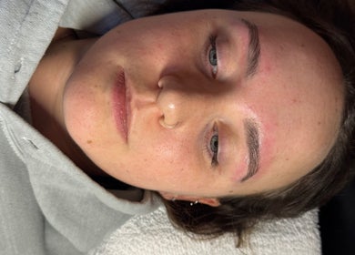Relaxed client enjoying a facial treatment at MUGG'D, Ponteland, England, GB, highlighting fresh skin and eyebrows.