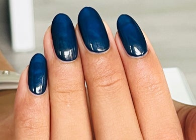 Stylish navy blue manicure at Manpreet Nail Studio in London, England, GB, showcasing modern nail art.