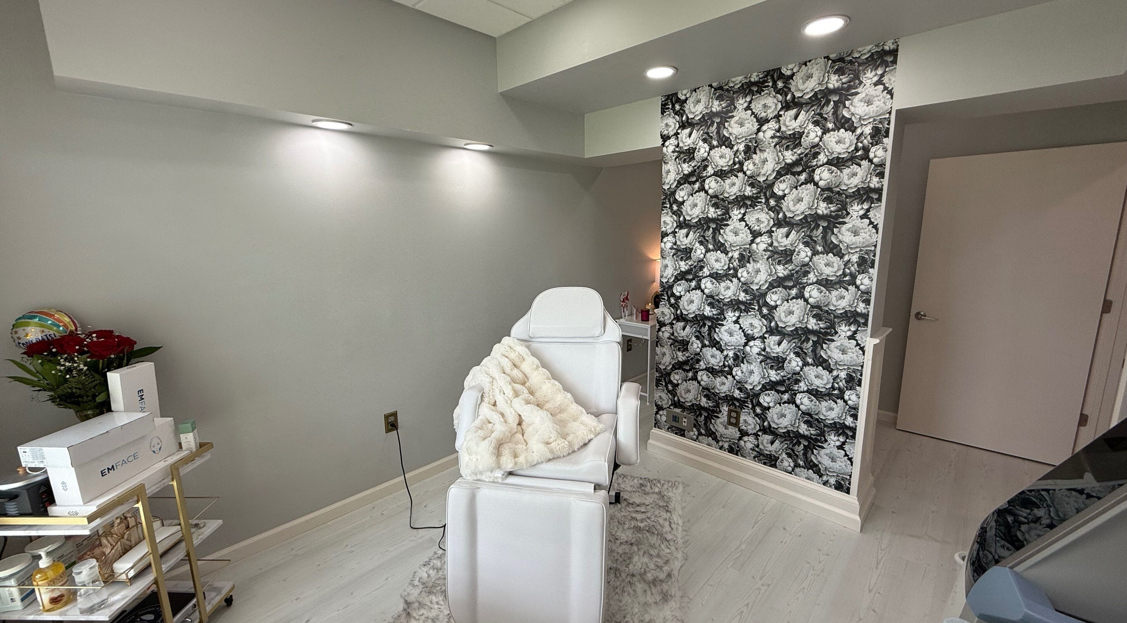 Luxurious treatment room at Dandridge Dental and Facial Esthetics, Dothan, Alabama, US with white chair and floral wall.