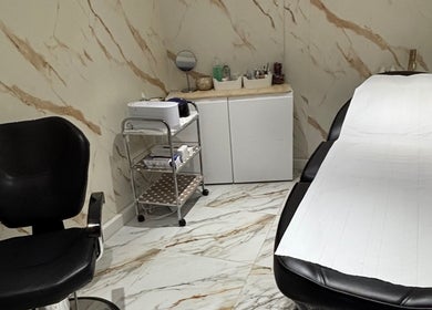 Elegant treatment room at USA Star Beauty, London, England, GB with chic black chair and massage table.