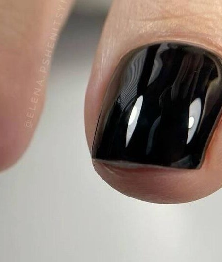 Sleek black polished toenail at Vicky’s Nails in Gendros, Wales, GB, showcasing expert pedicure skills.