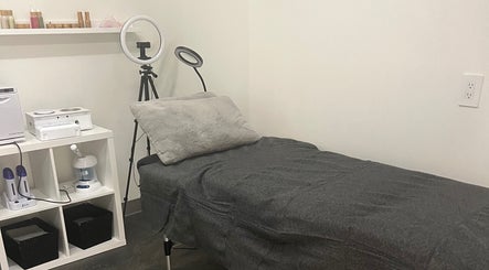 Cozy spa treatment room at Sérénité Bloom, Oakville, Ontario, CA with a treatment bed and ring light.