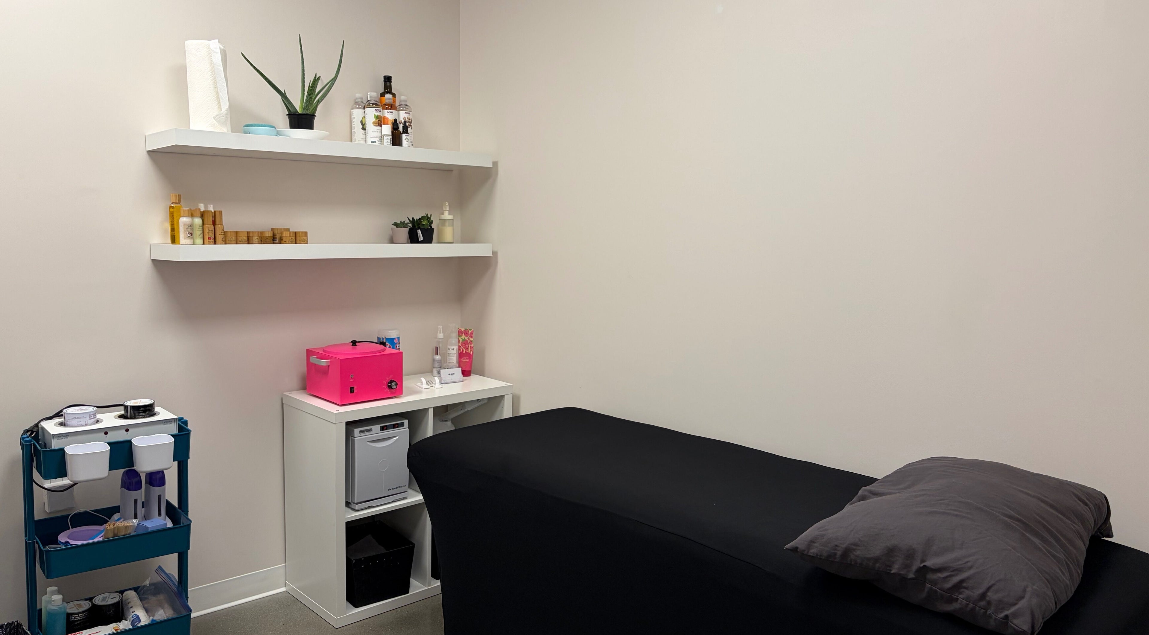 Relaxing treatment room at Sérénité Bloom in Oakville, Ontario, CA, featuring a modern design with a massage bed.