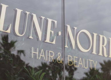 Lune Noire's elegant glass facade at Ir-rabat Għawdex, MT, showcasing the salon's sophistication.