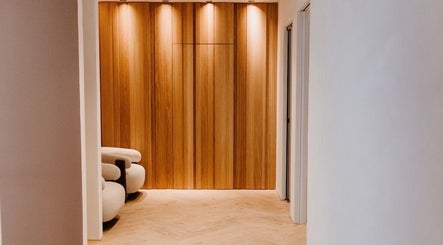 Warmer Empfangsbereich bei DR. SHAFÉ Dental Spa GmbH, Berlin, Berlin, DE mit stilvoller Holzverkleidung.