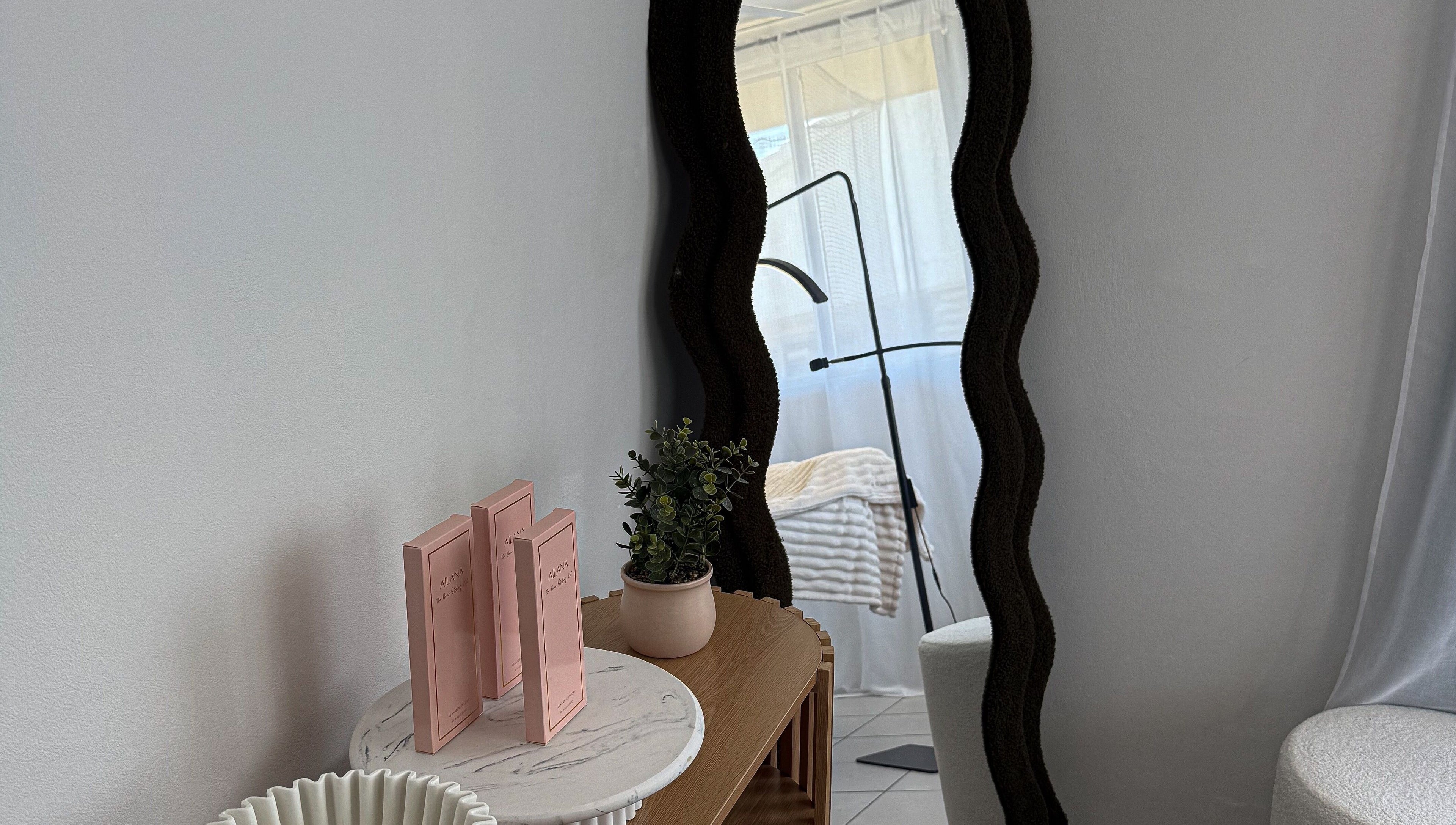 Elegant mirror and decor in Arch Aesthetic Co. at Palm Beach, Queensland, AU enhances the serene atmosphere.